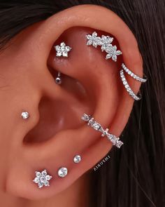 a woman's ear with three different piercings