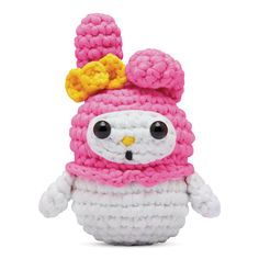 a crocheted stuffed animal wearing a pink and white outfit with a gold crown