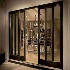 an open glass door leading into a dining room