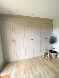 an empty room with white cupboards and a potted plant