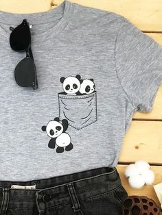 a t - shirt with pandas in the pocket on it and some sunglasses next to it