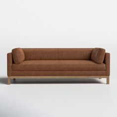 a brown leather couch sitting on top of a white floor next to a wooden frame