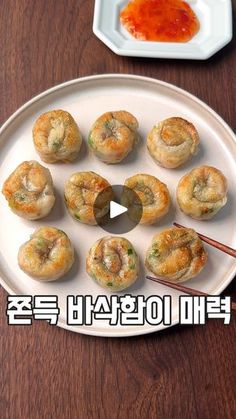 a white plate topped with small pastries on top of a wooden table next to chopsticks