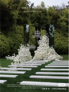 an outdoor ceremony setup with white flowers and greenery on the grass, in front of trees