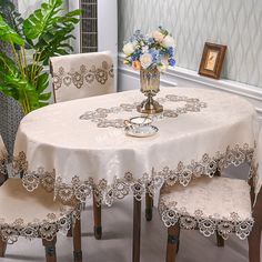 a table with four chairs and a vase filled with flowers