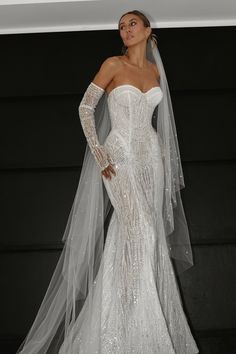 a woman in a white wedding dress with a long veil on her head and shoulders