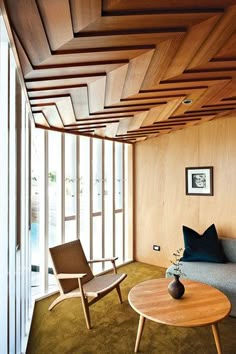 a living room filled with furniture and wooden paneled walls next to a large window