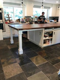 a man standing in a kitchen next to an island