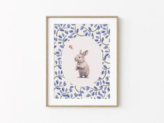 a framed art print of a rabbit holding a flower