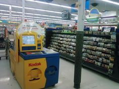 a kodak machine is in the middle of a grocery store's aisles,