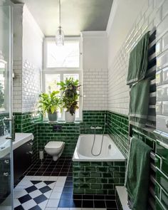 a bathroom with green and white tiles on the walls