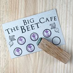 a rubber stamp sitting on top of a wooden table next to a piece of paper