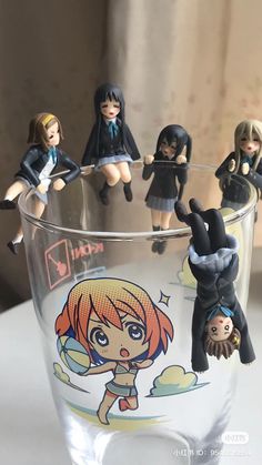 a glass filled with small figurines sitting on top of a table