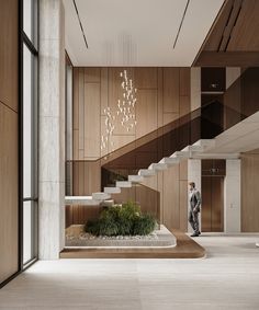 a man is walking down the stairs in a modern building with wood paneling and white walls