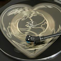 a turntable with a heart shaped design on the side and a black handle that is attached to it