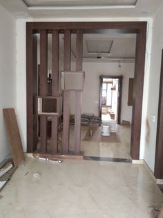 an empty room that is being renovated with wood and tile on the floor, in front of a doorway