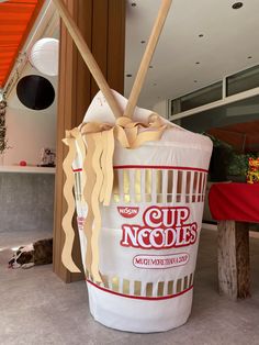 a large cup noodles bucket sitting on the ground