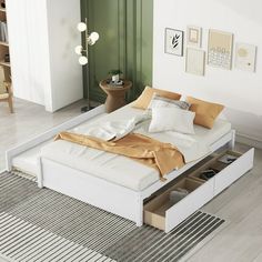 a white bed with two drawers underneath it