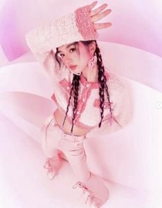 a girl with long braids wearing a pink hat and white sweater is posing for the camera