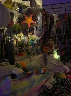 a bed with lots of stuff hanging from it's sides and lights on the ceiling