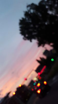 blurry image of traffic lights and trees at dusk