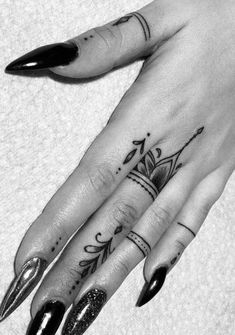 a black and white photo of a woman's hand with some tattoos on it