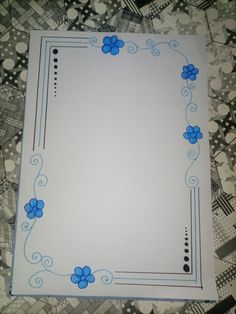 a sheet of paper with blue flowers on it sitting on a tablecloth covered floor