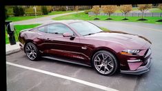 a maroon mustang parked in a parking lot