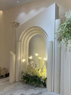 a room with columns and flowers on the floor