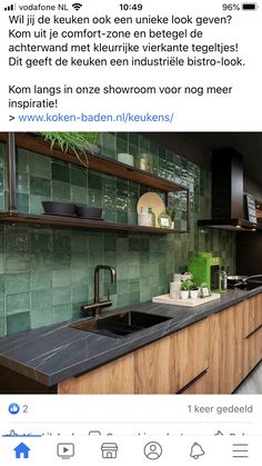 a kitchen with green tiles on the wall and black counter tops in front of it