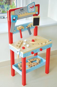 a wooden toy work bench with tools on it