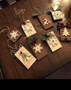 christmas ornaments are hanging on the table with ribbons and tags attached to each ornament