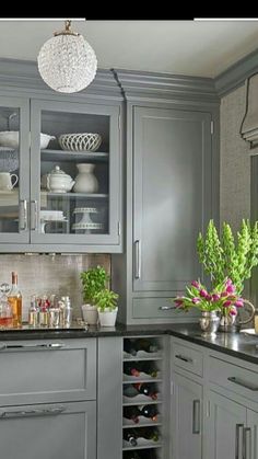 a kitchen filled with lots of gray cabinets and counter top space next to a window