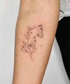 a woman's arm with flowers and butterflies on it