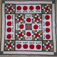 an apple quilt is displayed on the floor