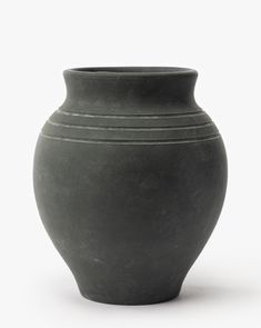 a black vase sitting on top of a white table