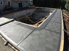 a house being built with the roof still attached to it's foundation and walls