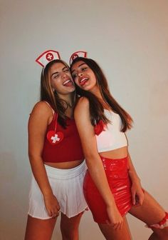 two young women in red and white outfits posing for a photo with their arms around each other