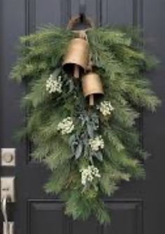 a wreath with bells hanging from it on the front door to greet someone who is waiting for them