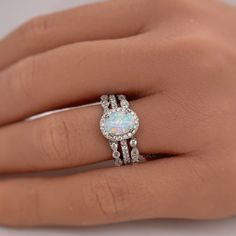 a woman's hand with a ring on it and an opal in the middle