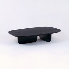 a black surfboard sitting on top of a white table