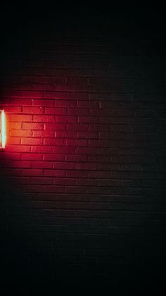 a brick wall with a red light on it