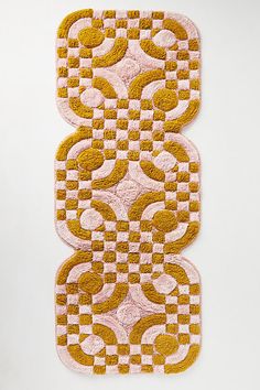 two yellow and pink rugs sitting on top of a white floor next to each other