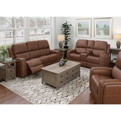 a living room filled with brown furniture in front of a large window and wooden floors