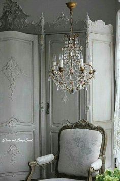 an antique chair and chandelier in a room