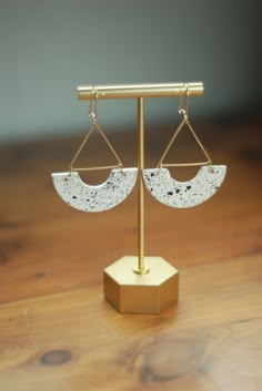 a pair of earrings sitting on top of a wooden table