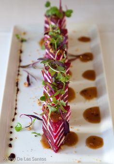 a white plate topped with food and garnishes on top of each other