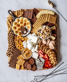 a platter filled with different types of snacks and desserts on top of a marble table