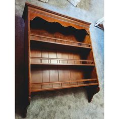 an old fashioned wooden bookcase sitting on the floor