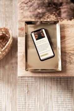 an iphone case sitting on top of a wooden table next to a basket and bowl